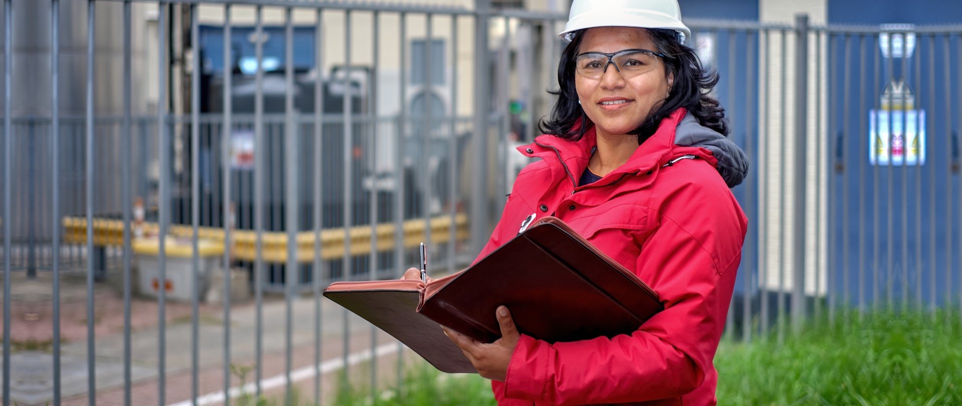 Vrouw met helm: inspecteur op locatie met containers